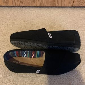 Women’s Toms classic black slip ons. Size 7.5